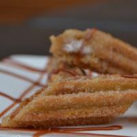 Churro · Fried pastry filled with caramel, rolled in cinnamon sugar and topped with caramel drizzle a...