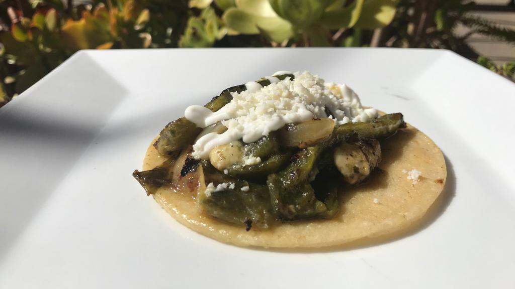 Rajas Con Queso Taco · Sliced fresh pasilla peppers sautéed with oaxaca and queso fresco cheeses, and additional spices. Topped with sour cream and dried cotija cheese.
