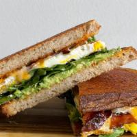 Breakfast Sandwich · Sourdough bread, 2 organic fried eggs, bacon, avocado, arugula, Cheddar, Swiss & Muenster ch...