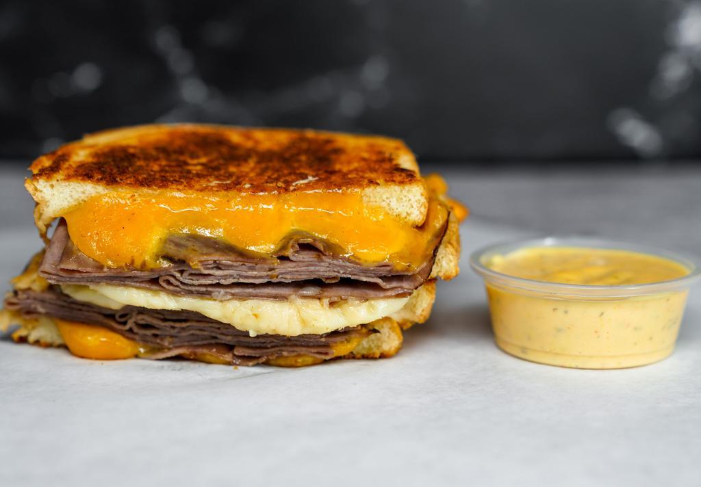 Roast Beef & Three Cheese Melt · Roast Beef, Cheddar, Swiss, and Parmesan cheeses melted between buttery, toasted sourdough bread. Served with a side of Spicy Honey Mustard Aioli.