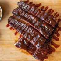 1 Slab Pork Ribs · TWELVE SMOKED RIB BONES WITH A DRIZZLE OF BARBECUE SAUCE.