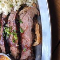 Slow-Roasted Tri-Tip- · Perfectly seasoned, slow-roasted tri-tip, thinly sliced and served on top of flash fried oni...