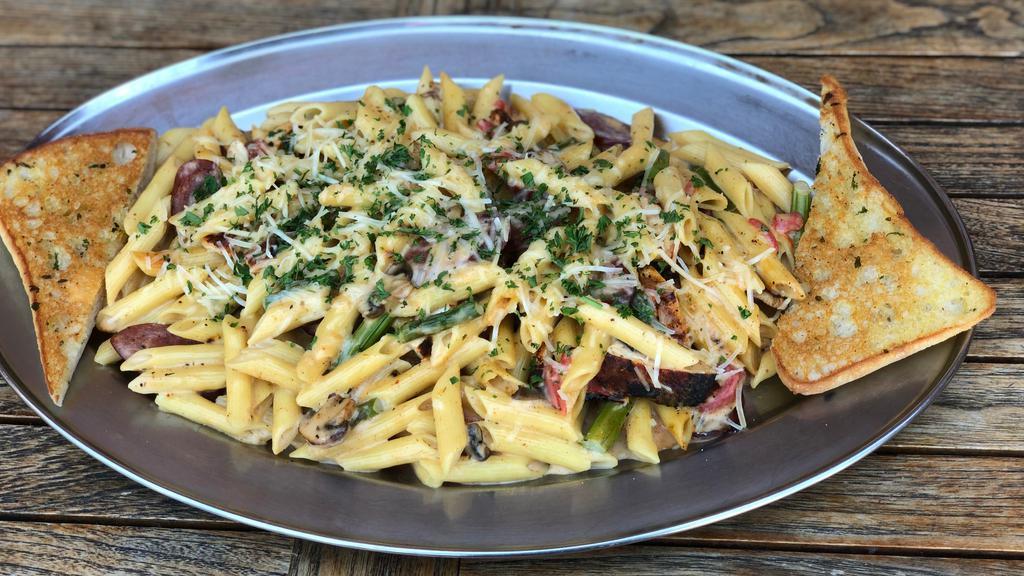 Bayou Cajun Pasta · Penne pasta sauteed with blackened chicken breast, smoked sausage, asparagus, mushrooms, bell peppers and garlic, all tossed in a creamy Cajun sauce and topped with shredded Parmesan. Served with garlic bread.