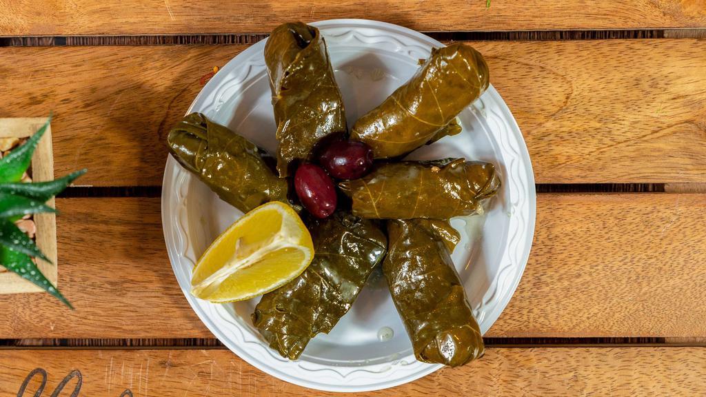 Dolmeh · Tender vine leaves stuffed with whole grain rice and herbs, served with olives and lemon.