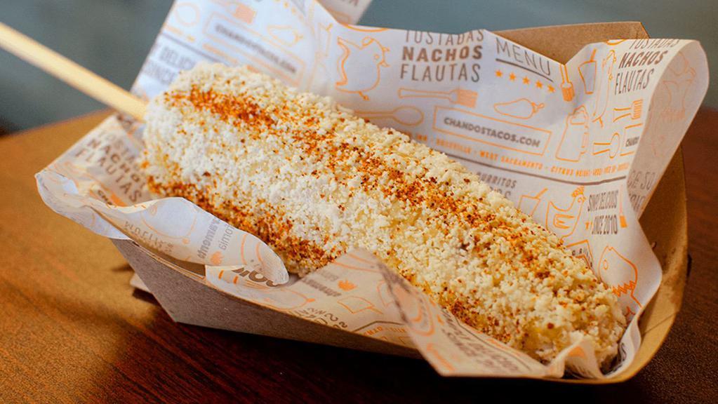 Elote · Corn on the cob topped with cotija cheese, tajin, and mayonnaise.