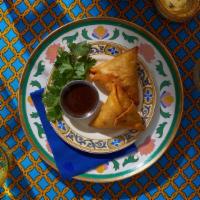 Vegetable Samosas · Two samosas filled with seasoned potatoes and peas and wrapped in a light pastry.