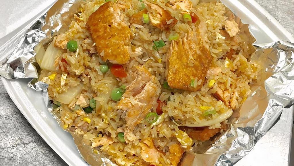 Salmon Fried Rice · Pan fried rice with egg, Salmon, peas and carrots, onion, tomato and fresh cucumber.