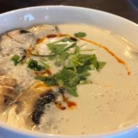 Tom Kha Chicken · Coconut based soup with chicken, cilantro, mushrooms, and chili oil.