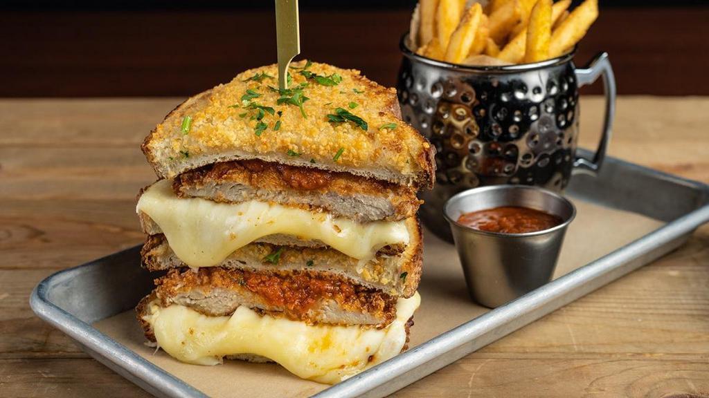 Chicken Parm Grilled Cheese · crispy buttermilk marinated chicken breast, spicy marinara, creamy herb cheese, Tillamook ™ white cheddar, mozzarella and provolone cheeses, toasted parmesan crusted sourdough, served with extra sauce for dipping.