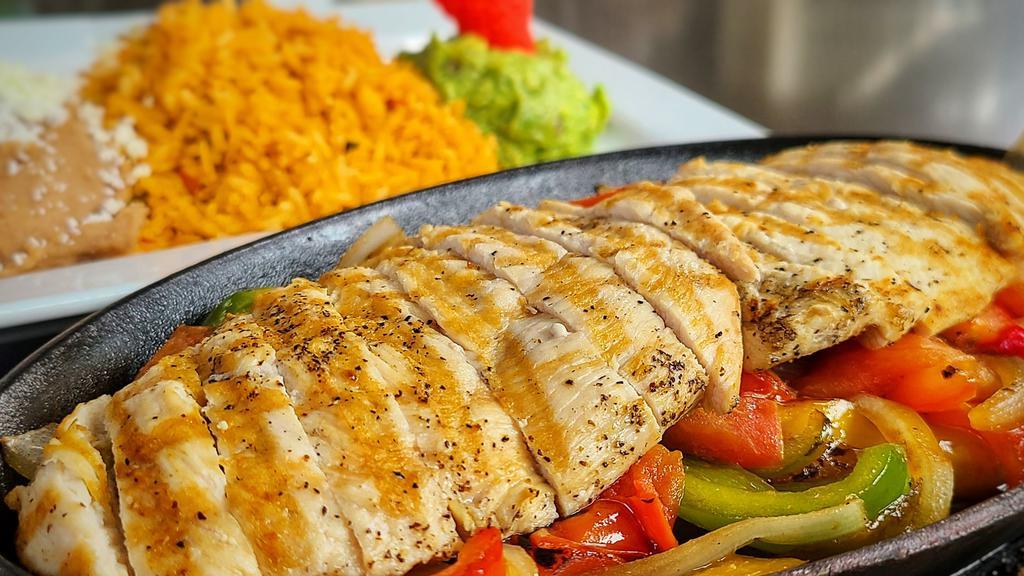 Chicken Fajitas · Grilled chicken tenders with sautéed tomatoes, green bell peppers, and onions. Served with rice, refried beans, guacamole, and handmade corn tortillas.