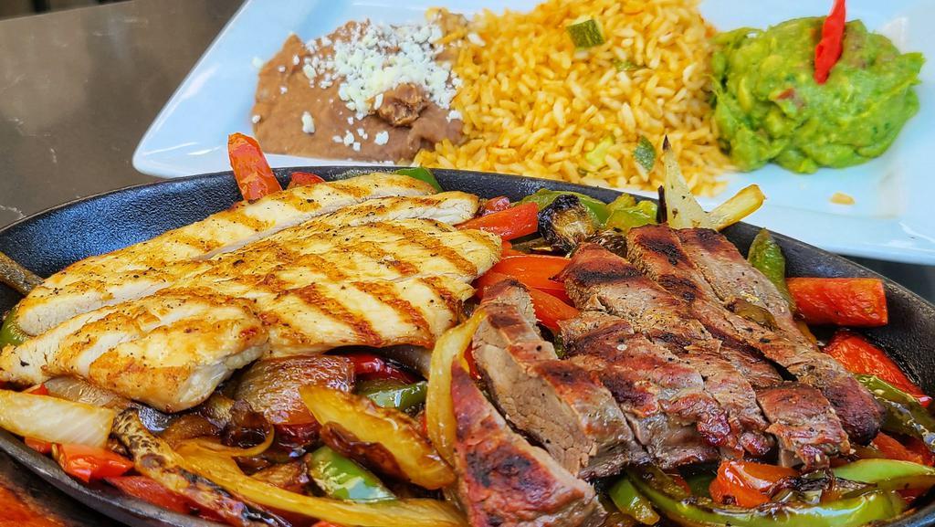 Fajitas Mixta · Grilled chicken and tenderloin strips with sautéed tomatoes, green bell peppers, and onions. Served with rice, refried beans, guacamole, and handmade corn tortillas.