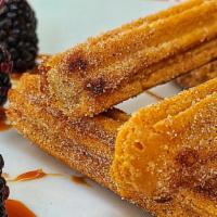 Churros · Churros rolled on cinnamon sugar, served with a side of Cajeta sauce.