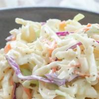 Creamy Coleslaw · Shredded cabbage, purple cabbage, carrots tossed in our house made coleslaw mayo.