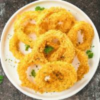Inverse Onion Rings · Sliced onions dipped in a light batter and fried until crispy and golden brown.