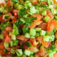 Israeli Salad · A delicious israeli salad with tomato, cucumber, onion, parsley, lemon juice, and a touch of...