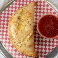Calzone · Homemade dough stuffed with ricotta, mozzarella, and Parmesan cheese, then baked and served ...