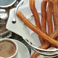 Churros Con Chocolate · Made with organic flour. Six classic crispy golden brown churros showered with sugar. A cup ...