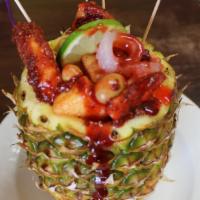 Piña Loca · Half pineapple filled with pickle pork skin, peanuts, tamarind candy, chamoy, clamato, hot s...