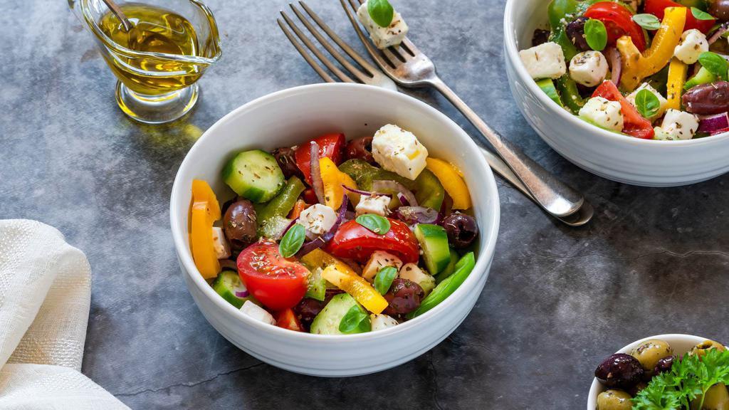 Greek Salad · Fresh salad made with Romaine lettuce, feta cheese, stuffed grape leaves, tomatoes, red onions, kalamata olives, cucumbers, and bell peppers.