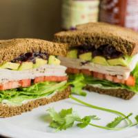 Turkey Avocado · Turkey breast with lettuce, tomato, avocado, and a spread of mayo and cranberry sauce on squ...