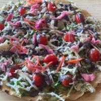 Guacamole Tlayuda · a large thin tortilla covered with guacamole spread, green cabbage, cilantro, cheese, heirlo...