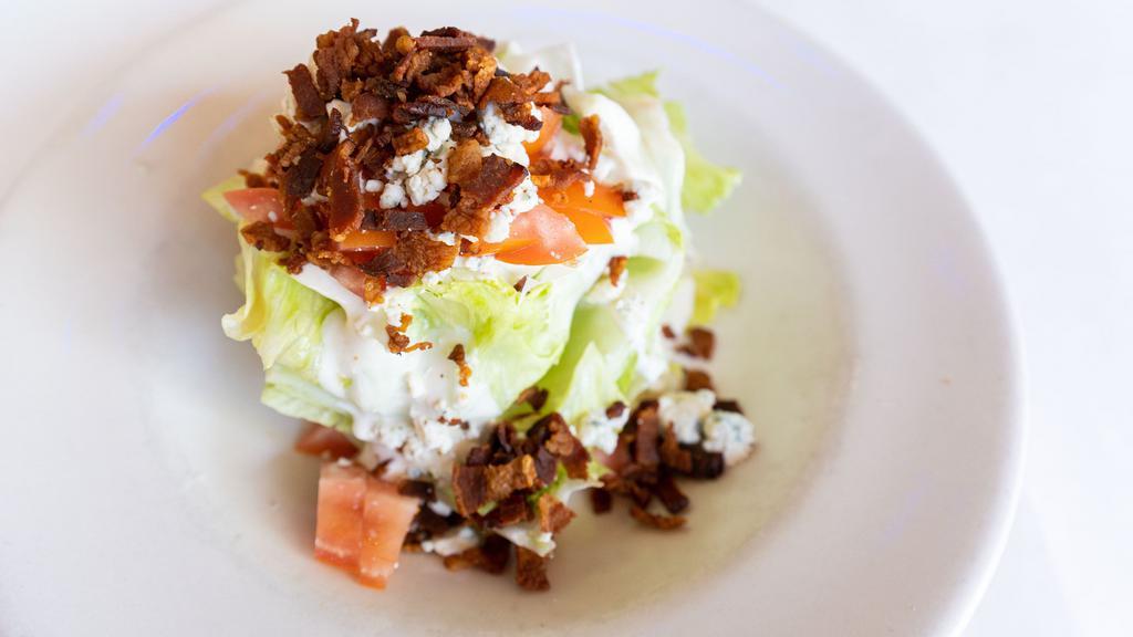 The Wedge Salad · Crisp iceberg lettuce, topped with creamy blue cheese dressing, blue cheese crumbles, diced tomatoes and bacon.