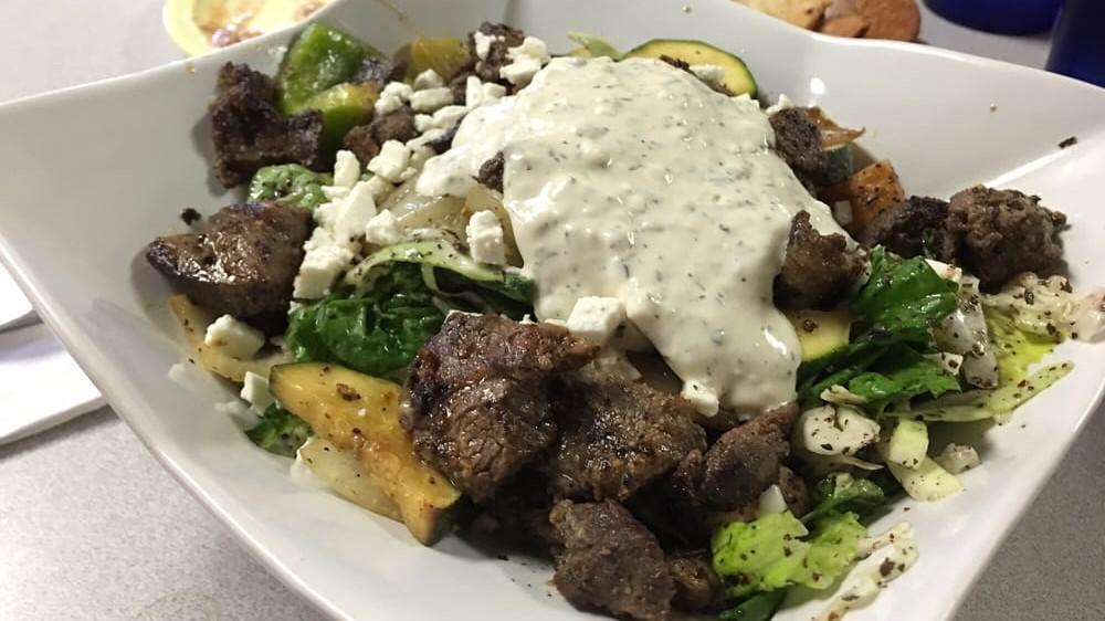 Beef Fatoush Salad · Fatoush salad topped with charbroiled beef grilled veggies feta cheese and tzatziki sauce