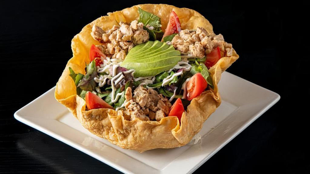 Tostada Chicken Salad · Tostada bowl filled with spring mix, grilled chicken, tomato, avocado, rice, refried beans, sour cream, and cheese. Tossed in a mandarin dressing.
