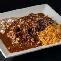 Mole Poblano · Shredded chicken covered in mole poblano. Served with rice, beans, and handmade soft corn to...