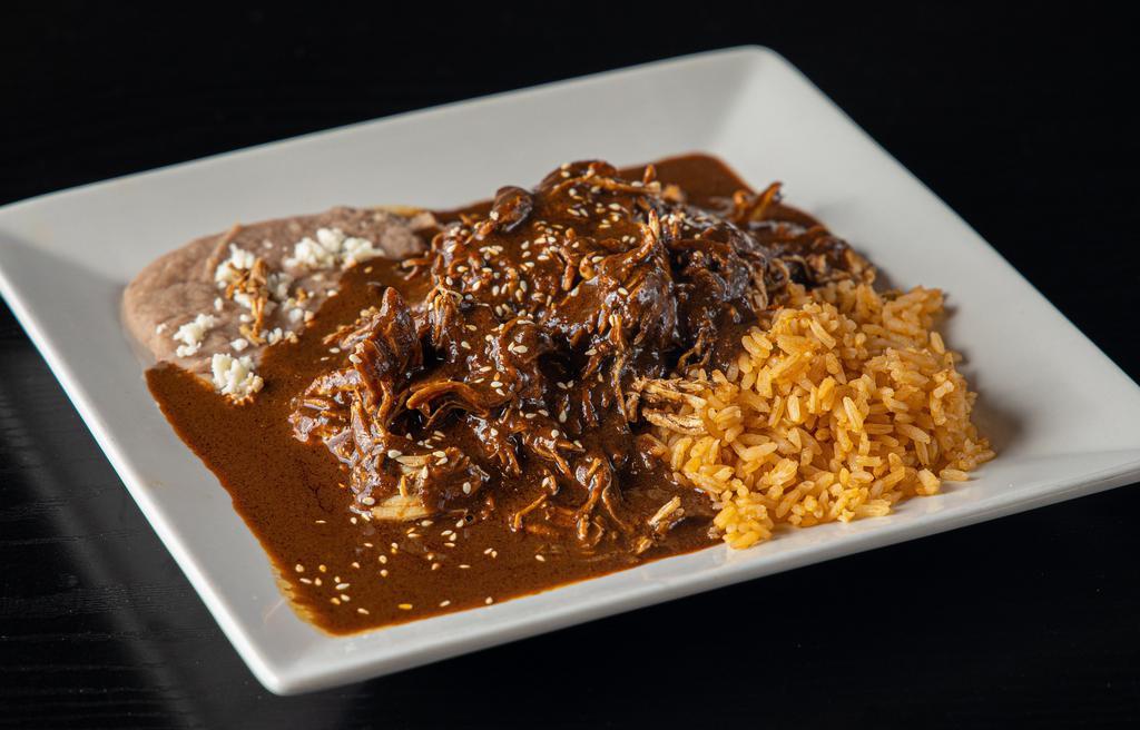Mole Poblano · Shredded chicken covered in mole poblano. Served with rice, beans, and handmade soft corn tortillas.
