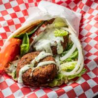 Falafel Wrap · Vegetarian. (Balls) wrapped in a soft pita with fresh onions, tomatoes, tzatziki, and tahini...