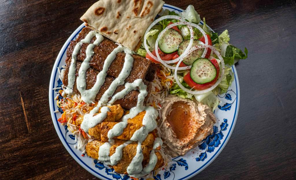 Combo Plate · Chicken and gyro over long-grained basmati rice with tzatziki, tahini sauces, and side of salad.