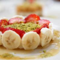 Ashta B'Aasal · Carousel-made ashta layered over fresh banana topped with honey and pistachios.