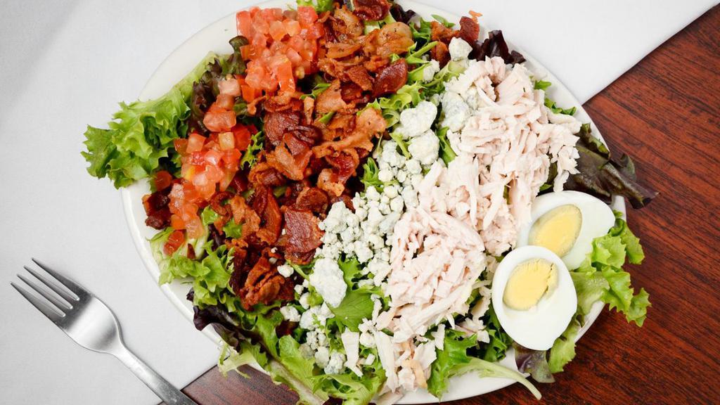 Cobb Salad · Sliced oven-roasted turkey diced bacon tomatoes sliced hard-boiled egg and blue cheese crumbles served on a bed of leafy greens.