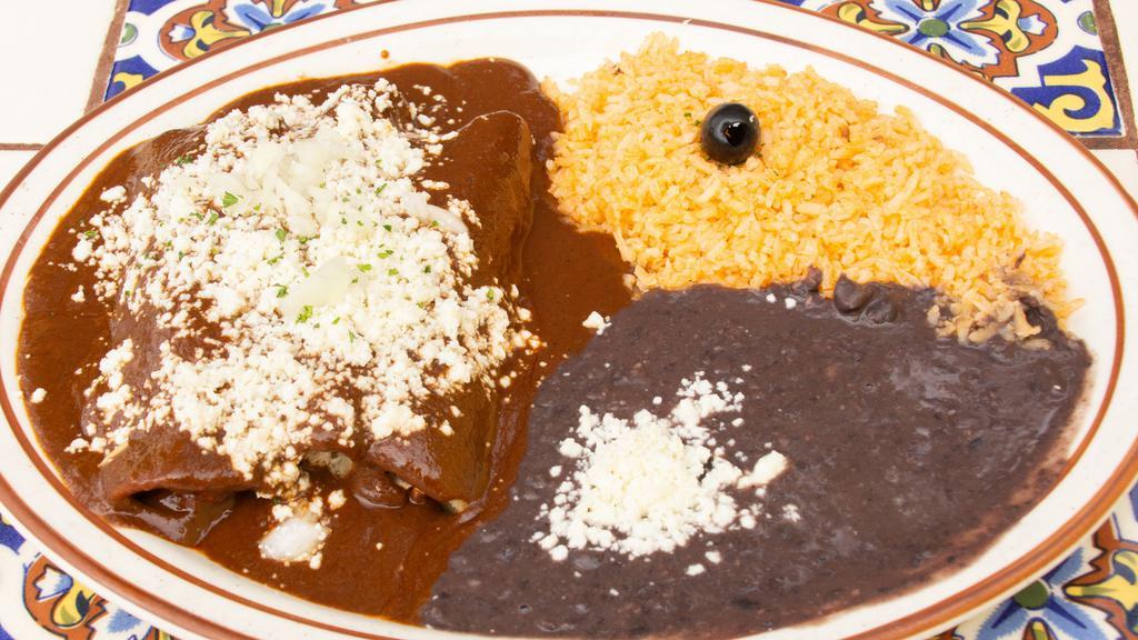 Enchiladas De Mole · Gluten free. Three corn tortillas filled with chicken breast or cheese, topped with our special mole sauce, onions and cheese. Served with rice and black beans. Beans are garnished with Mexican cheese.