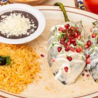 Chiles En Nogada · Poblano peppers stuffed with meat, dried fruits, nuts and topped with pecan sauce. Served wi...