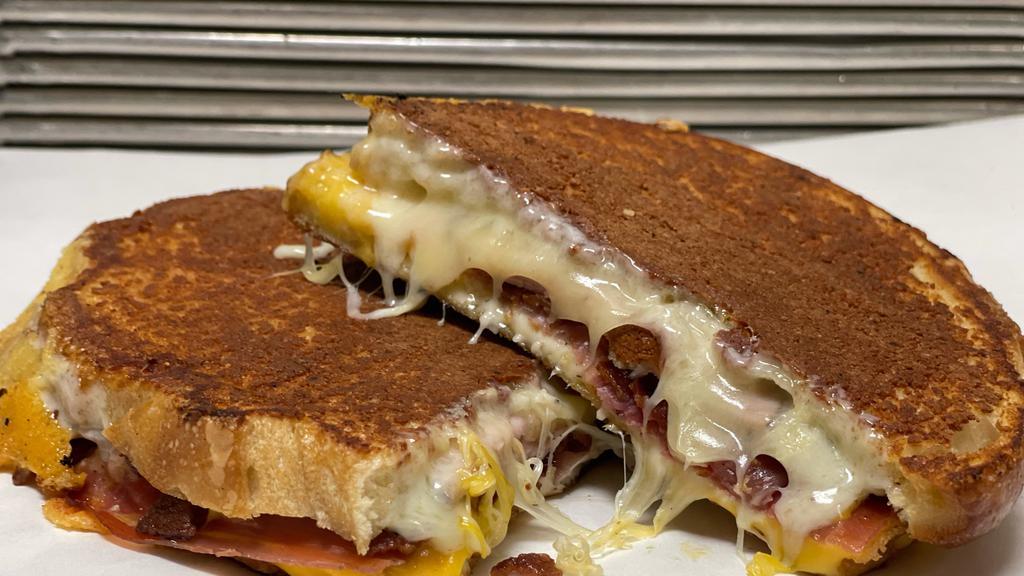 The Hog - The Ultimate Grilled Ham And Cheese · Smokey cheddar, fontina, muenster, prosciutto, bacon and black forest ham on parmesan crusted sourdough.