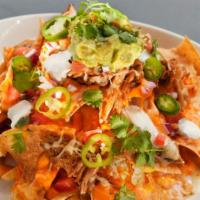Pulled Pork Nachos · House-smoked pulled pork, pickled jalapeño, pepper jack, cheese sauce, tomatoes, cilantro, g...