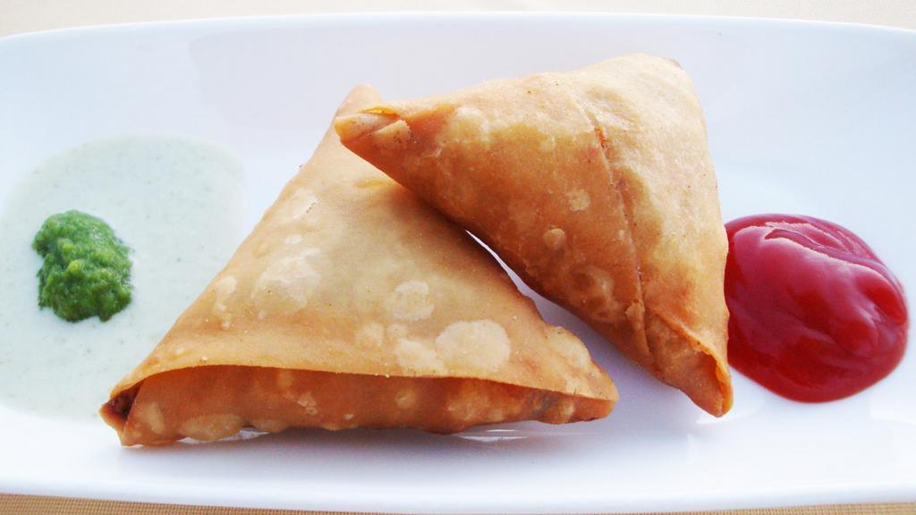 Samosa · Two traditional crispy fried pastry stuffed with spices, potatoes and peas.