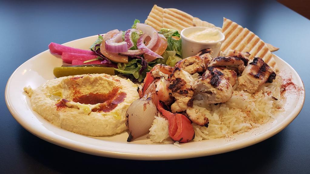 Chicken Kabab Plate · 2 skewers of grilled marinated chicken cubes served with rice, hummus, salad, garlic sauce, and pita bread.