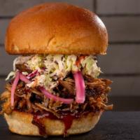 Pulled Pork Sandwich · Slow cooked pulled pork, house made BBQ sauce, pickled onion, coleslaw on a pretzel pun.