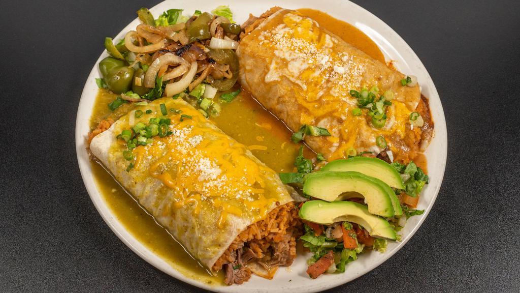 Los Compadres · Brothers from different mothers burrito half filled with chile Colorado and the other half with chile verde cut and served side by side with rice and beans. Cotija cheese, bell pepper, onion, pico de gallo, and avocado garnish.
