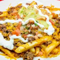 Carne Asada Fries · French fries with asada, refried beans, cheddar cheese, guacamole, and sour cream.