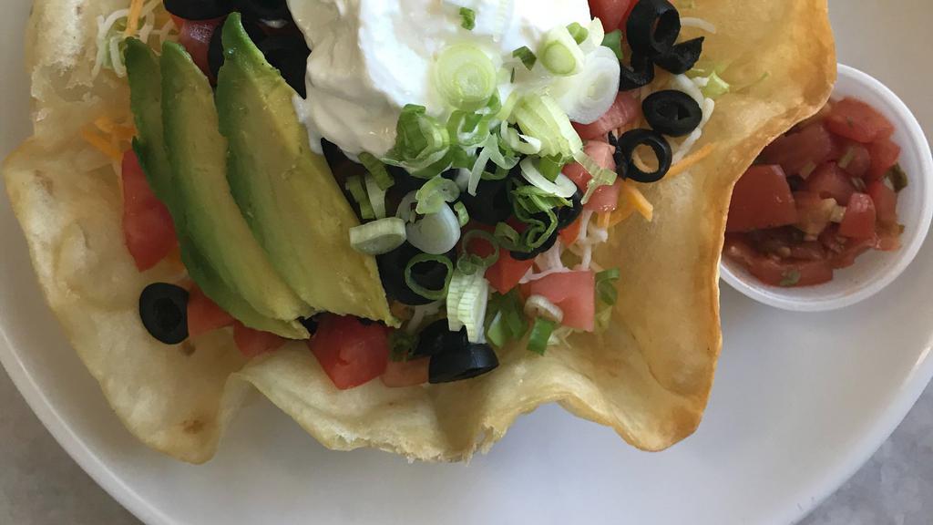 Taco Sald Dish · Seasoned beef, avocado, pinto beans, shredded lettuce, olives, diced tomatoes, shredded cheese, sour cream, & scallions in a crispy shell with our homemade salsa on the side.