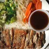 Teriyaki Chicken Dish · Grilled chicken served with steamed broccoli, cabbage, carrots, & bean sprouts served with r...