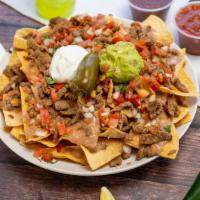 Super Nachos · Chips, refried beans, Monterrey jack cheese, choice of meat, onions, cilantro, tomatoes, sou...
