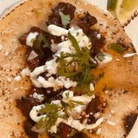 Carne Asada · Mexicali-style skirt steak, salsa roja, crema, queso fresco, onions, cilantro. Served on han...