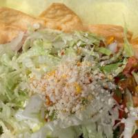 Taco Salad Tostada · Served with beans, cheese and lettuce