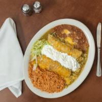 Enchiladas Suizas · Two chicken enchiladas, covered with salsa verde and topped with sour cream and cheese.