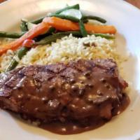 New York Steak · A savory 14 oz New York steak charbroiled served with a peppercorn sauce, fresh vegetables a...
